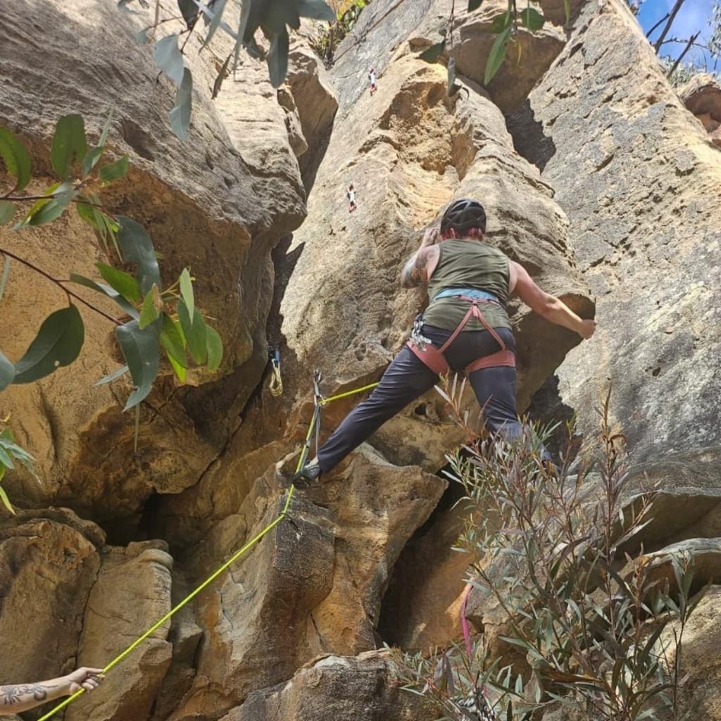Dr Mara Hickey rock climbing on sandstone