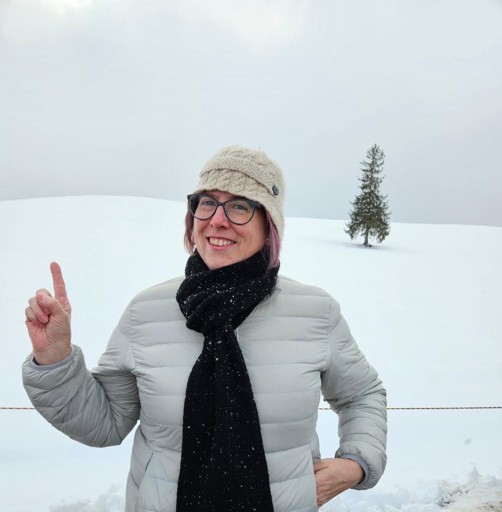 Dr Mara Hickey in a snowy landscape pointing skyward